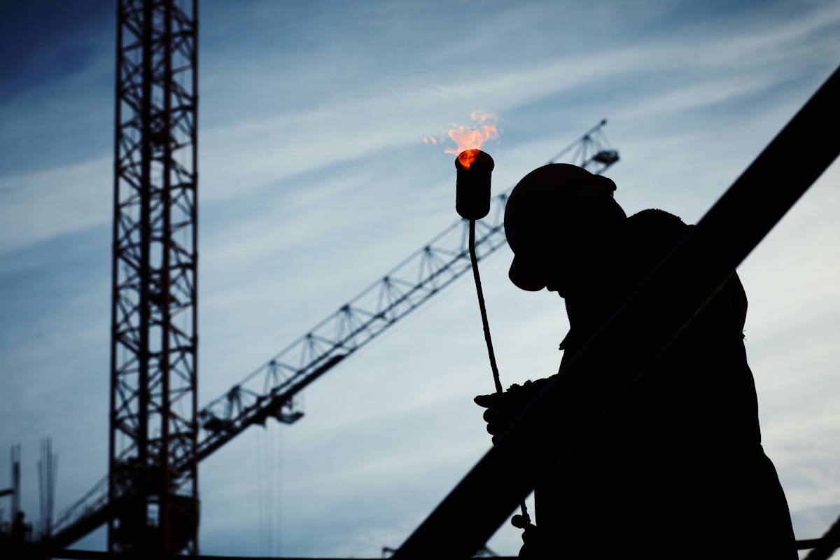 Construction and industrial workers at a jobsite where asbestos exposure commonly occurred in pipes, insulation, and building materials